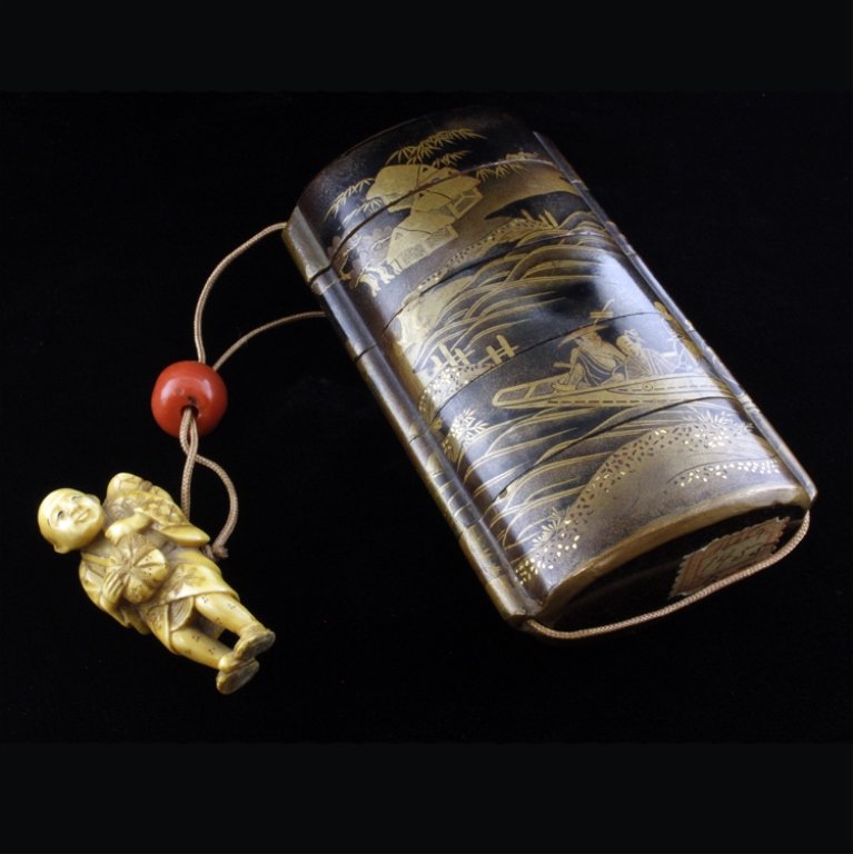 Japanese Inro, Ojime and Netsuke: Est $ 300-500 19th century Japanese 4 case gold lacquer Inro with a figural man Netsuke and a red Ojime. The Inro is painted with a scenic design of people in a boat on a river with houses and a bridg