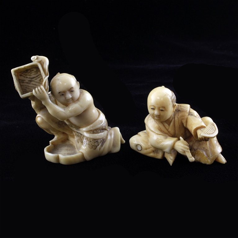 Set of Two Ivory Netsuke: Est $ 150-300 Two figural men netsuke made of ivory. 1) A man on one knee holding a box with a mouse that is signed on the bottom. 1 1/4" w x 1 3/4" t. 2) A man with a small chip on his foot. 1 1/2" w