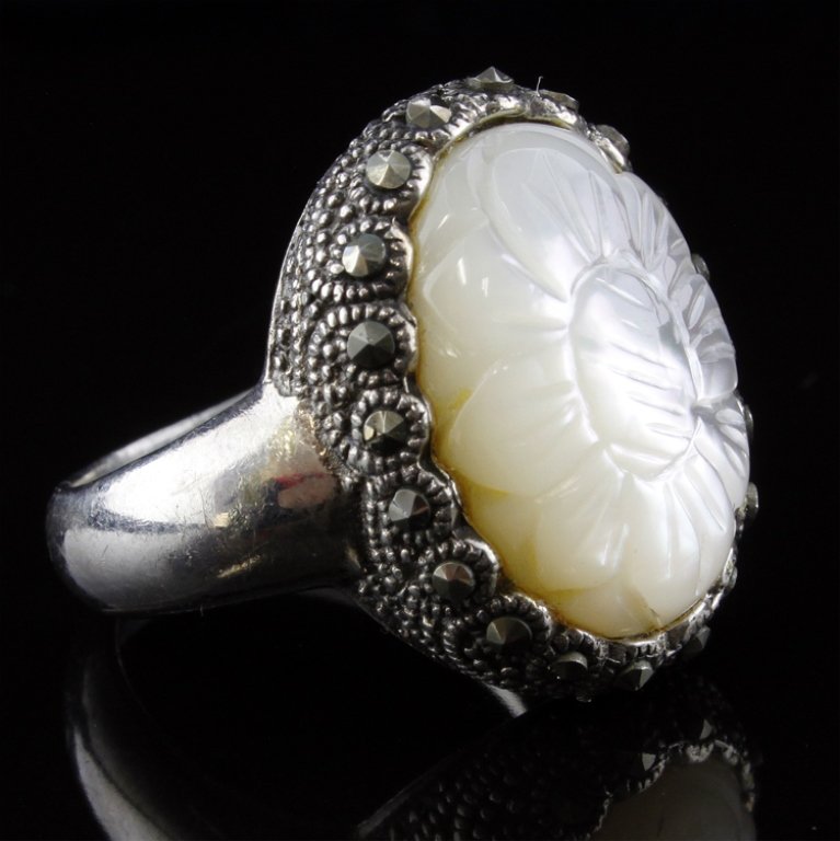 Mother of Pearl Sterling Ring: Est. $15 - 35 Mother of Pearl Sterling Ring. Weighs 7.8 grams. Flower cut design in MOP. Marcasite accents.
