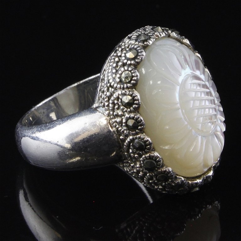 Mother of Pearl Sterling Ring: Est. $15 - 35 Mother of Pearl Sterling Ring. Weighs 7.8 grams. Flower cut design in MOP. Marcasite accents.