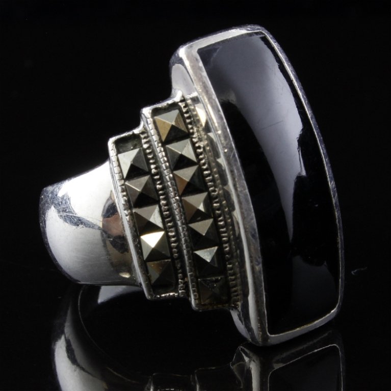 Sterling Ring with Black Onyx & Marcasite: Est. $40 - 70 Sterling Ring with Black Onyx & Marcasite. 9.9grams tw. Gemstones: inlaid black Onyx with marcasite accents. Marks 925.
