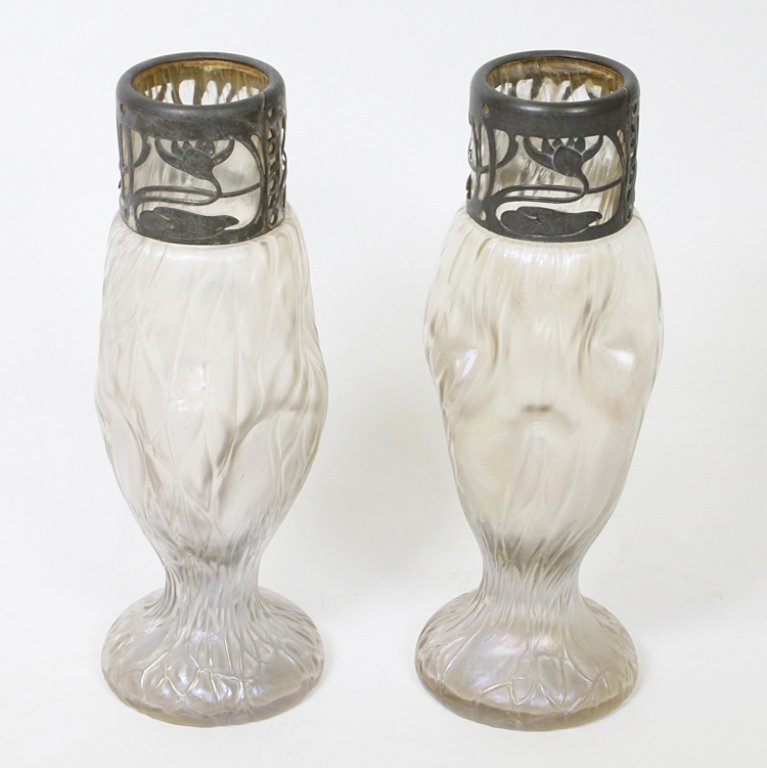 Pair of Two Loetz Style Art Glass Vases: Est $ 250-400 Set of two iridescent art glass vases with metal overlay. The vases are Loetz style unsigned and measure 8 1/4" tall. Third party shipping.