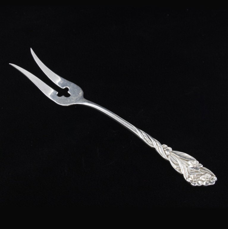 Sterling Frank Whiting Forget-Me-Not Fork: Est. $20 - 40 Pickle/ Olive fork with the 1895 Forget-me-Not pattern. It is marked sterling next to the makers mark, it measures 4 3/4" long and weighs .24 ozt.