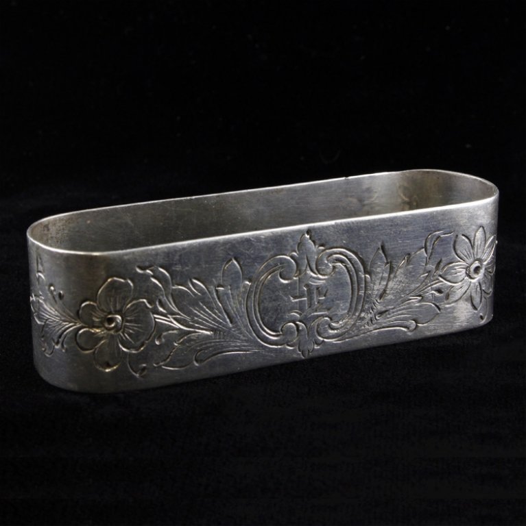 J.F. Fradley & Co. Sterling Napkin Ring: Est. $25 - 50 Napkin ring monogrammed with the letter F inside an etched floral pattern. Marked Sterling & J.F. Fradley & Co., it measures 2 3/4" long x 3/4" tall and weighs .68 ozt.