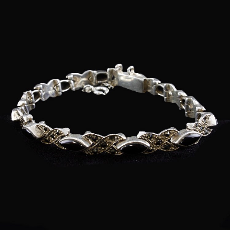 Sterling, Marcasite and Onyx Bracelet: Est. $20 - 40 Sterling, Marcasite and Onyx Bracelet. Measures 7.5 inches long. Weighs 16.0 grams. Few small missing marcasite. Safety chain. Marked 925.