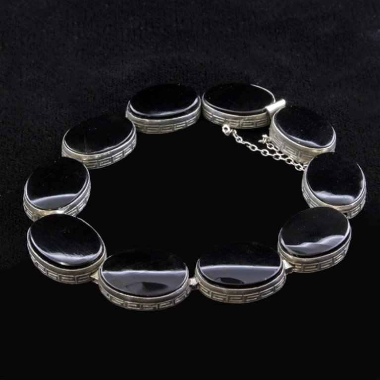 Onyx and Sterling Bracelet: Est. $20 - 40 Onyx and Sterling Bracelet. Measures 7 inches long. Weighs 13.5 grams. Has safety chain attached.