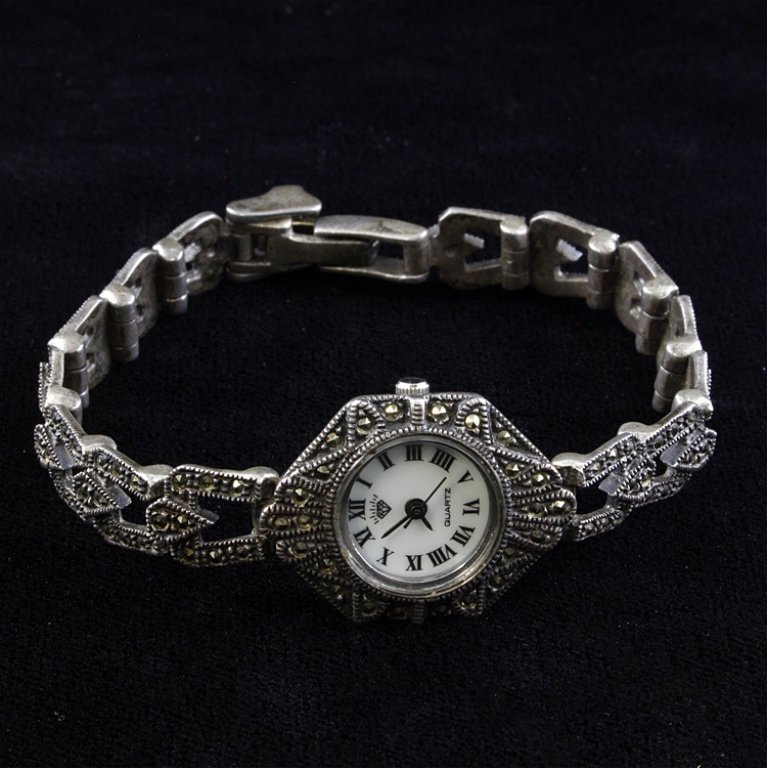 Sterling and Marcasite Quartz Watch: Est. $40 - 60 Sterling and Marcasite Quartz Watch. Measures 7 inches. Not working. Weighs 34.1 grams.