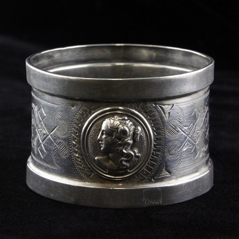 American Coin Silver Napkin Ring: Est. $18 - 27 American Coin Silver Napkin Ring. Weighs 0.49 ozt. American coin silver engraved and applied medallion napkin ring. Measures 1.75 x 1.125 inches.