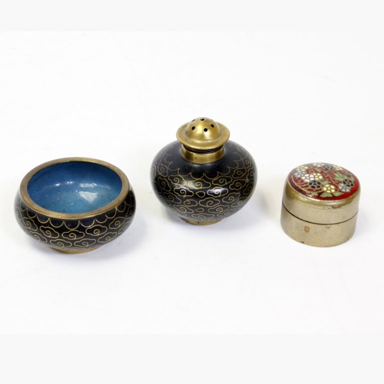 Cloisonne Pill Box, Open Salt, and Pepper Shaker: Est. $30 - 45 Cloisonne Pill Box, Open Salt, and Pepper Shaker. (1) Small brass and cloisonne enamel pill box with floral theme. Marks: Siam. Measures 1 1/4" x 7/8". (1) small brass and cloisonne open