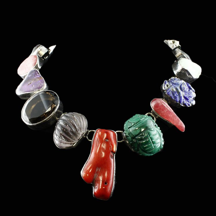 Rebecca Collins "Bless Our Earth" Necklace: Est. $150 - 250 Rebecca Collins "Bless Our Earth" Necklace. Sterling: 231.75 grams tw. Gemstones: Variety of stones and custs. Includes Coral, Rutile Quartz, Amethyst, Malachite, Hematite and more. To