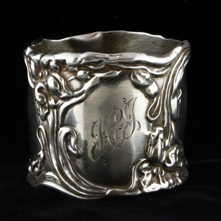 Sterling Holloware Napkin Ring: Est. $30 - 40 Sterling Holloware Napkin Ring. Weighs .87 ozt. Measures 1.5" tall and 1.75" wide. Marked Sterling. Some wear on ends. Monogrammed
