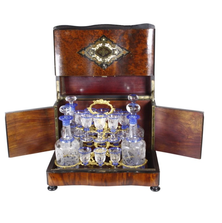 Cave a Liqueur: Est. $1000 - 1200 Cave a Liqueur. 2nd half of 19th century. (4) Mouth blown decanters, 16 liqueur glasses, all engraved and painted. Inlaid brass and mother of pearl in the lid and the face. Selected 