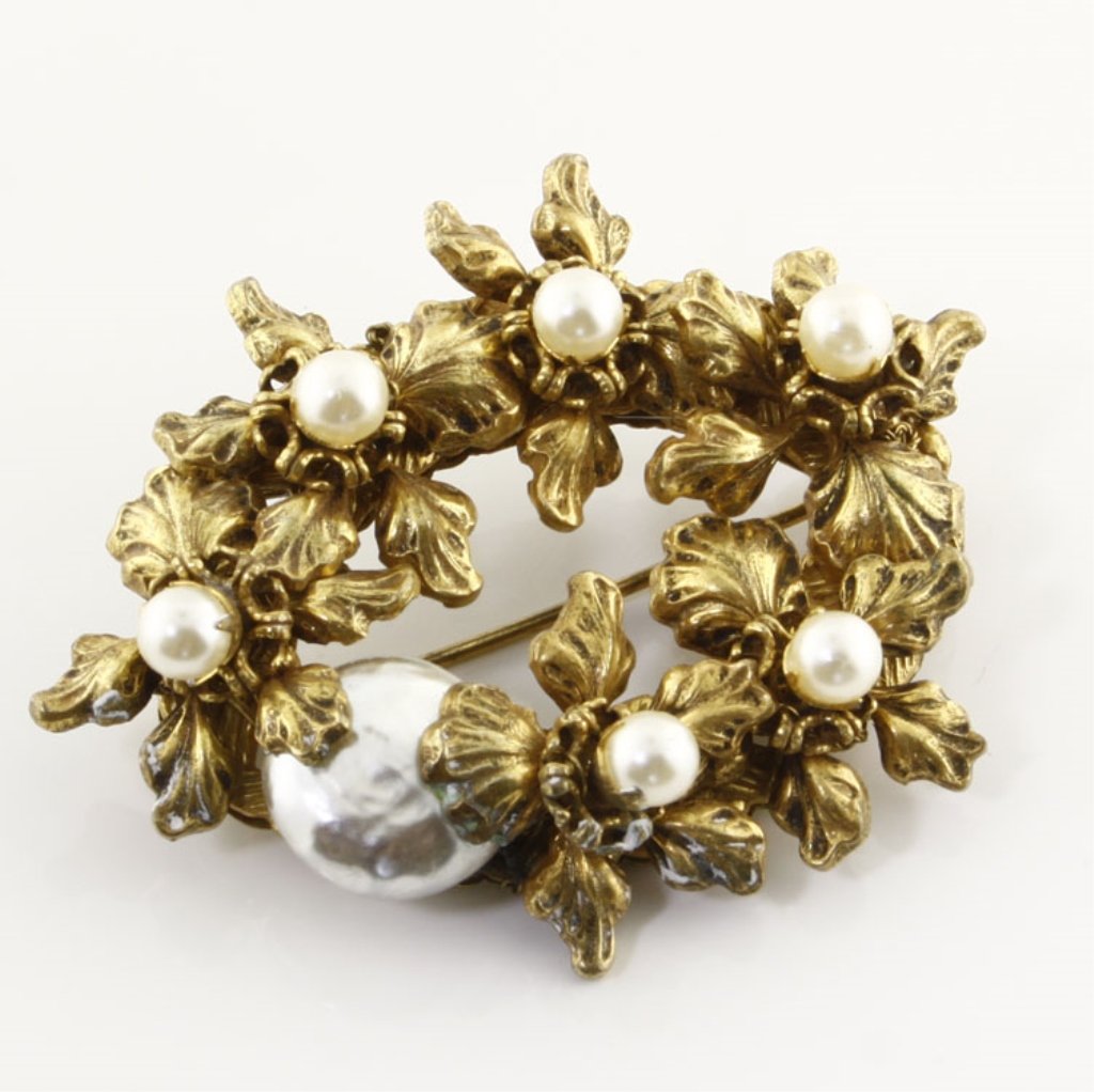Vintage Miriam Haskell Pearl Pin Brooch: Est. $125 - 200 Vintage Miriam Haskell Pearl Pin Brooch. Gold tone floral pin brooch with round and baroque pearl elements. Accents are prong and wire set. 2 1/8 x 1 5/8". Marks: Miriam Haskell.