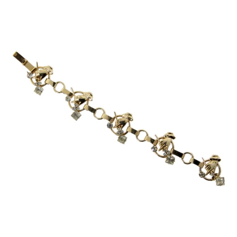 Vintage Gold Tone Bracelet: Est. $ 20 - 30 Vintage Gold Tone Bracelet. Gold tone bracelet hand holding a wand theme links. Rhinestone accents. Missing some stones. 7 in long. (See lot 51 for matching necklace).