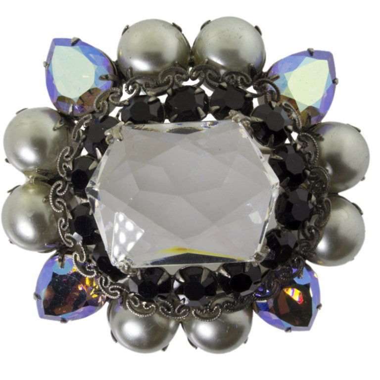 Schreiner New York Vintage Brooch: Est. $ 150 - 350 Schreiner New York Vintage Brooch. Vintage brooch with central faceted glass element surrounded by black and aurora borealis stones and light gray faux pearls. Marked Schreiner New Yo