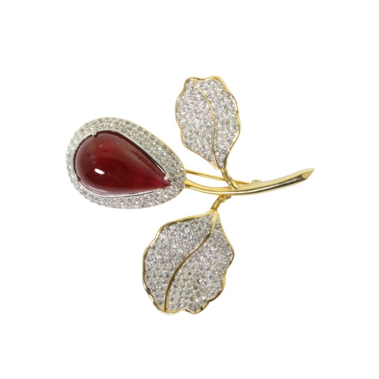 Nettie Rosenstein Rhinestone Trembler Brooch: Est. $ 50 - 125 Nettie Rosenstein Rhinestone Trembler Brooch. Gold tone floral brooch with trembler leaves. Pear cabachon carnelian colored center with rhinestone accents. 2.50 inches long. Marked Net