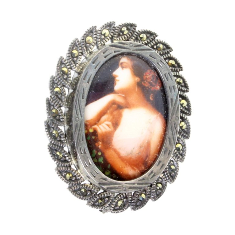 Sterling Porcelain Cameo Brooch: Est. $ 30 - 50 Sterling Porcelain Cameo Brooch. Measures 1.5 inches tall. Marcasite accents. Sterling bezel.