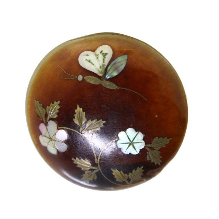 Inlaid Amber Button: Est. $ 35 - 65 Inlaid Amber Button. Inlaid amber button, inlaid in yellow metal, and Mother of Pearl, in a floral and lepidopterous motif
