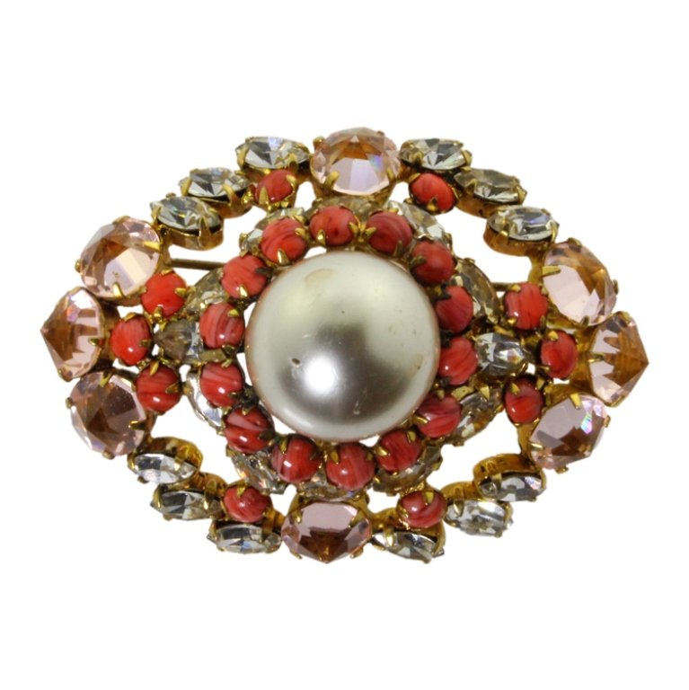 Vintage Schreiner NY Brooch: Est. $ 150 - 300 Vintage Schreiner NY Brooch. Gold tone brooch with faux pearl center, pink cabachon and rhinestones. Marked Schreiner New York. 2 3/8 nches long.