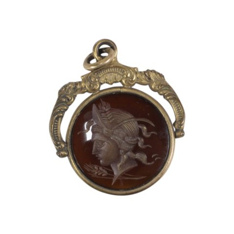 Vintage Intaglio Cameo Pendant: Est. $ 50 - 100 Vintage Intaglio Cameo Pendant. Gold tone pendant with round sand intaglio cameo. 1.25 x 1 inches overall.
