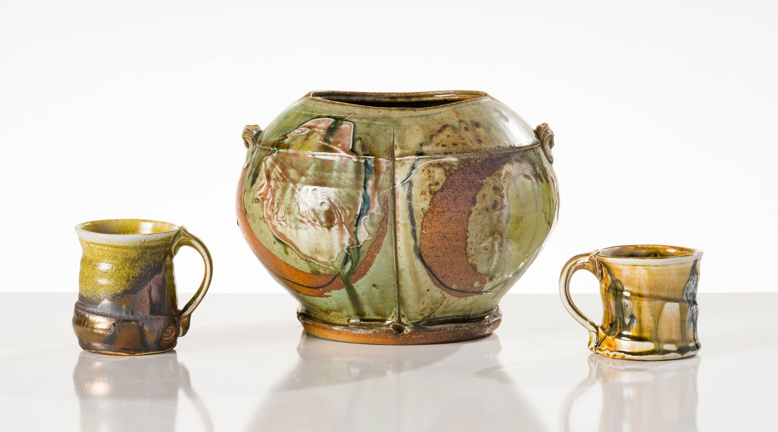 Josh DeWeese (1) Green Vessel & (2) Mugs: Josh DeWeese (American, b. 1963) (1) Green Vessel & (2) Mugs Ceramic with glaze 8.5 x 12 x 12 (in) Stamped JD, side of each work Dimensions reflect the vessel. Weight reflects the entire lot. Mugs mea