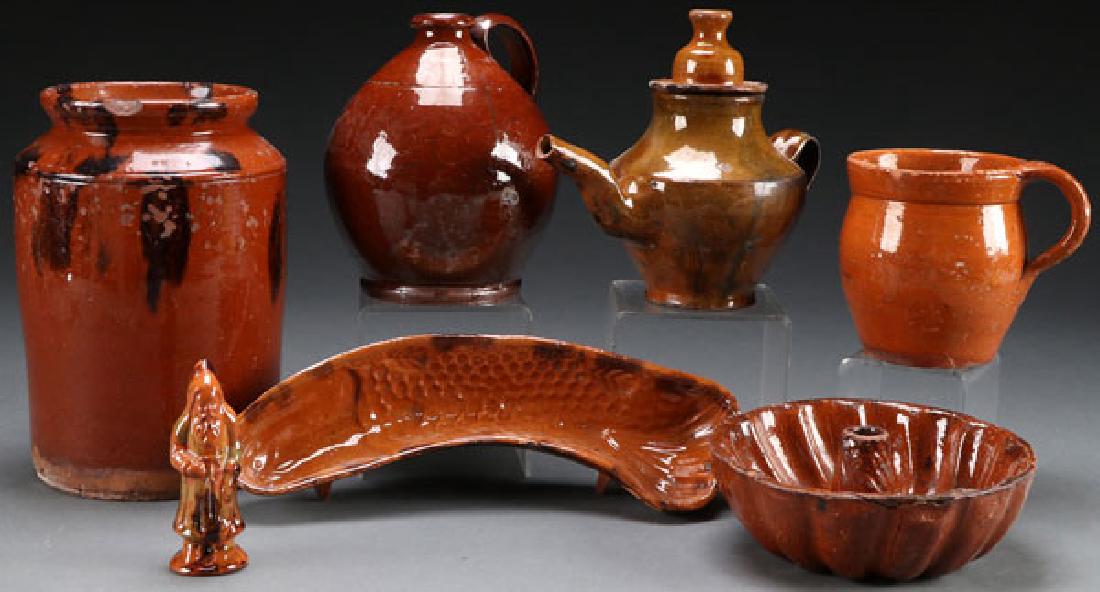 A SIX PIECE GROUP OF 19TH CENTURY GLAZED REDWARE: A SIX PIECE GROUP OF 19TH CENTURY GLAZED REDWARE. Comprising a half gallon jar with manganese spashes, an ovoid jug with applied handle, a tea pot, a handled mug, and two food molds, including a fish
