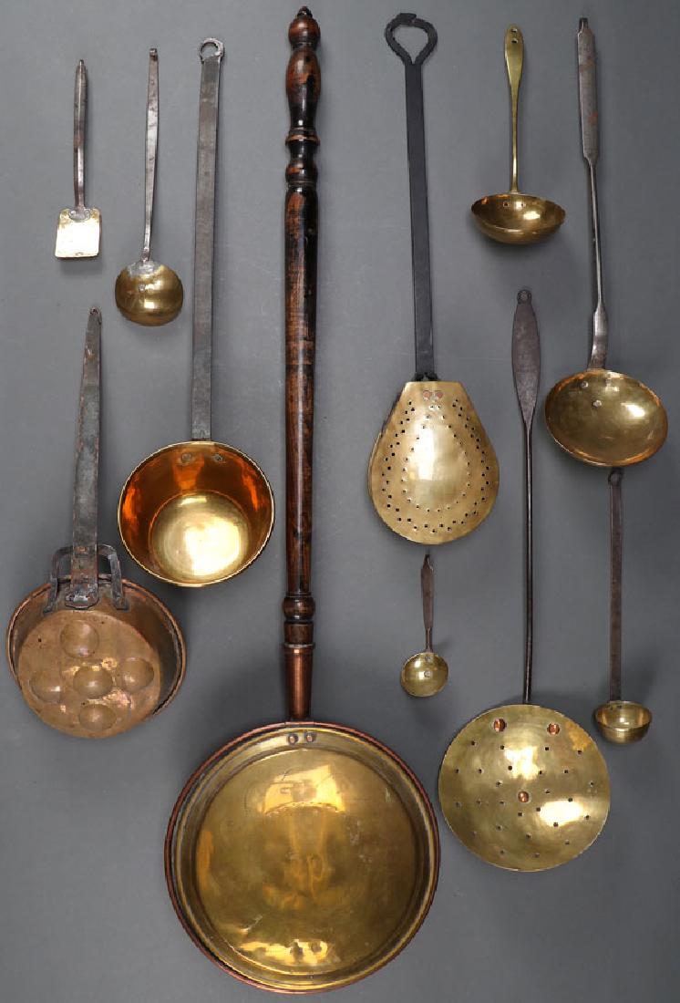 11 EARLY AMERICAN KITCHEN UTENSILS: A GROUP OF ELEVEN AMERICAN BRASS, COPPER, AND IRON ARTICLES, 19TH CENTURY. Comprising a copper and wood bed warmer. Together with a tear-shaped pan, two round pans, five ladles, a small spatula, and a