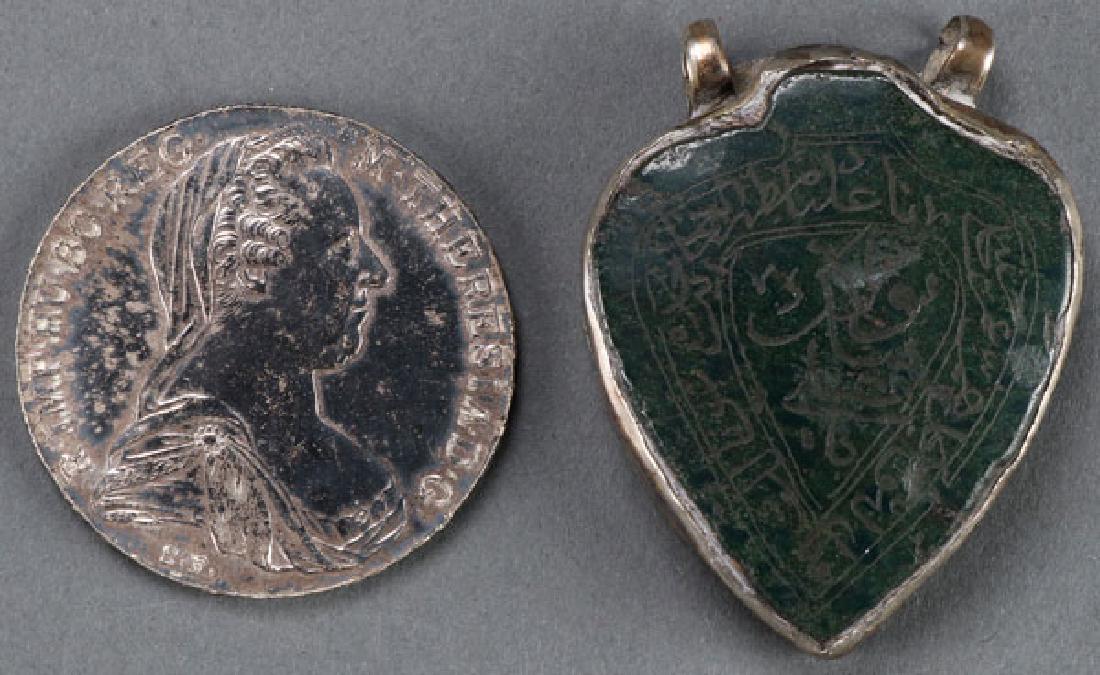 A 1780 MARIA THERESA THALER AND JADE PENDANT: A 1780 MARIA THERESA THALER AND JADE PENDANT. The pendant most likely Indo-Persian with silver backing and suspension loops engraved with an inscription. Length 2.1 inches (5.4 cm). SHIPPING NOTICE: J