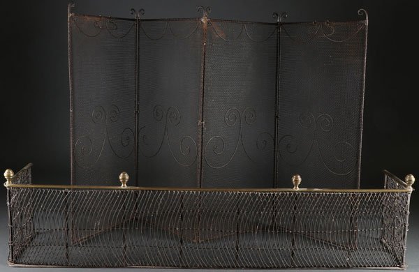 AN EARLY AMERICAN WROUGHT IRON AND BRASS FIRE FENDER: AN EARLY AMERICAN WROUGHT IRON AND BRASS FIRE FENDER, CIRCA 1800. With woven wire panels over a wrought iron frame raised on four shaped brass finials and with swinging end panels. Together with a sli