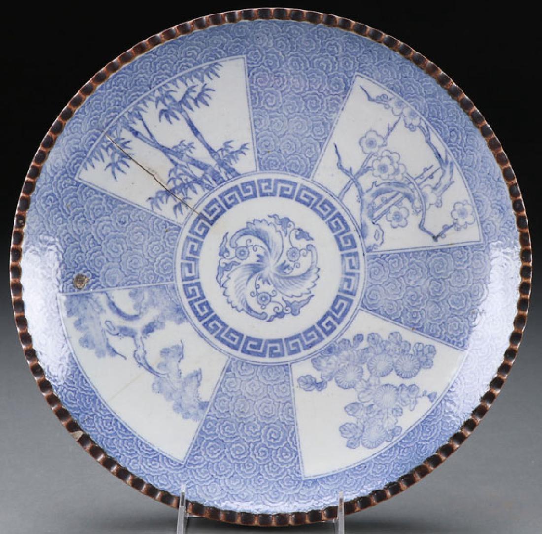 A CHINESE BLUE AND WHITE DECORATED CHARGER: A CHINESE BLUE AND WHITE DECORATED CHARGER, 19TH CENTURY. Decorated with four scenic panels reserved on a ground of overlapping rosettes with brown border. Diameter 12.3 inches (32.5 cm). SHIPPING NOT