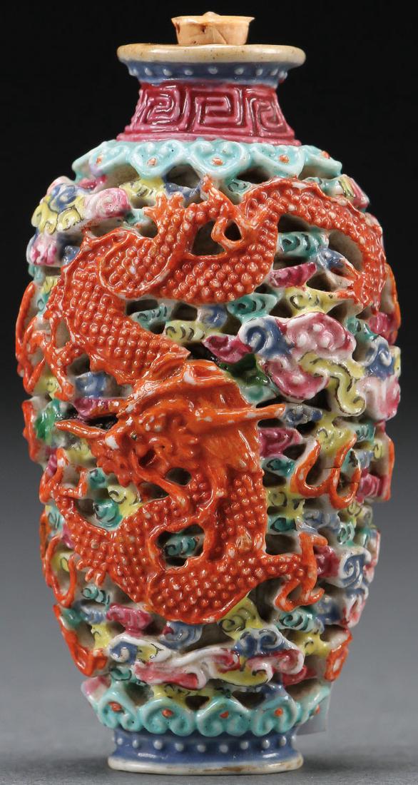 A CHINESE FAMILLE ROSE PORCELAIN SNUFF BOTTLE: A CHINESE FAMILLE ROSE PORCELAIN SNUFF BOTTLE. Well carved in deep relief with a dragon and phoenix. The base with red oxide archaic style mark. Height 2.75 inches. SHIPPING NOTICE: Jackson's is your 
