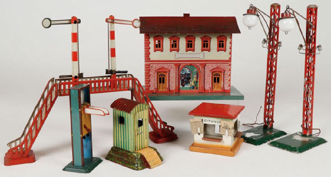 A GROUP OF SEVEN GERMAN TIN TRAIN ACCESSORIES (1 of 7)