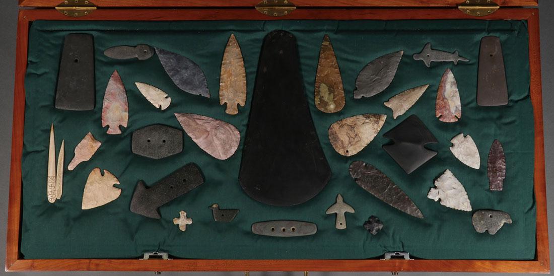 THIRTY CASED STONE OBJECTS: THIRTY CASED STONE OBJECTS. Including a variety of materials, shapes, and forms. Comprising gorgets, pendants, knife blades, and the like. Perhaps a few old examples; whereas, the others likely contem