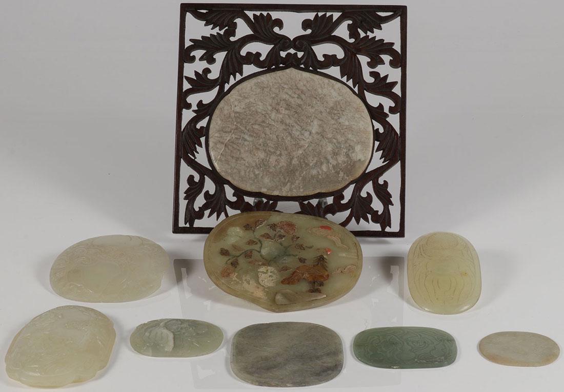 NINE CHINESE CARVED JADE AND JADEITE PLAQUES: A GROUP OF NINE CHINESE CARVED JADE AND JADEITE PLAQUES. Mostly oval in shape, carved in various themes and motifs, and one set on a carved wood lattice framework. Largest plaque 5.25 inches (14.5 cm)