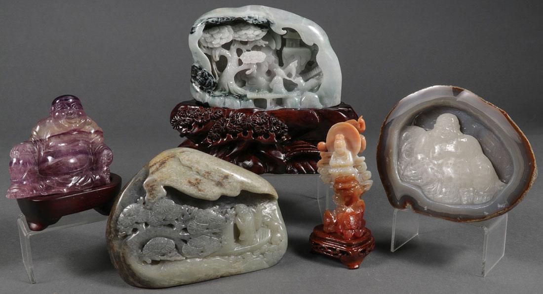 FIVE CHINESE CARVED HARDSTONES: A GROUP OF FIVE CHINESE BUDDHIST THEMED CARVED HARDSTONES. Including a carved seated amethyst Buddha, a carved relief Buddha within an agate, two scholar stones with immortals, and an agate carved fig