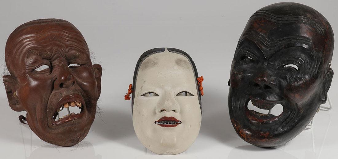 THREE JAPANESE CARVED MASKS: THREE JAPANESE CARVED NOH MASKS. Comprising a realistically carved grimacing man with open mouth, teeth, and real hair together with a woman and a laughing face two signed on the interior. Greatest me