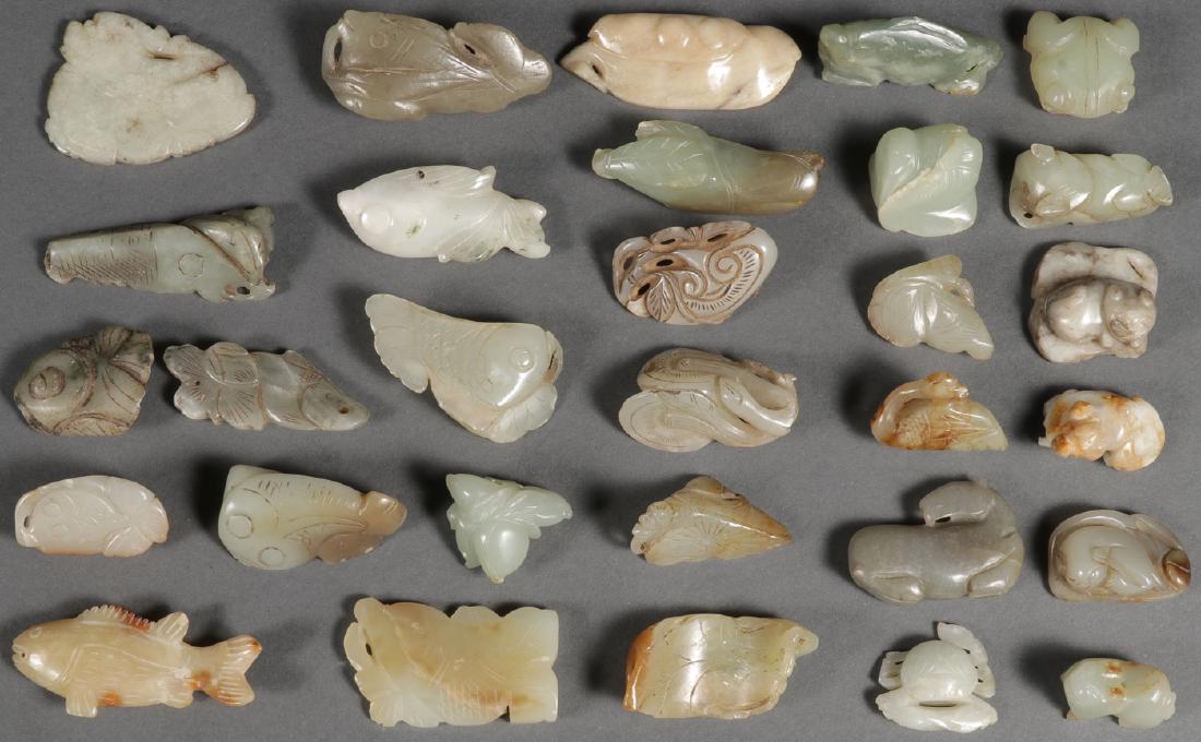 30 CHINESE CARVED JADE PENDANTS AND ORNAMENTS: A GROUP OF 30 CHINESE CARVED JADE PENDANTS AND ORNAMENTS, MOSTLY QING DYNASTY. Depicting various imagery including dragons, frogs, cats, fish, mushrooms, peapods, bird, horse, and crab. Some losses. G