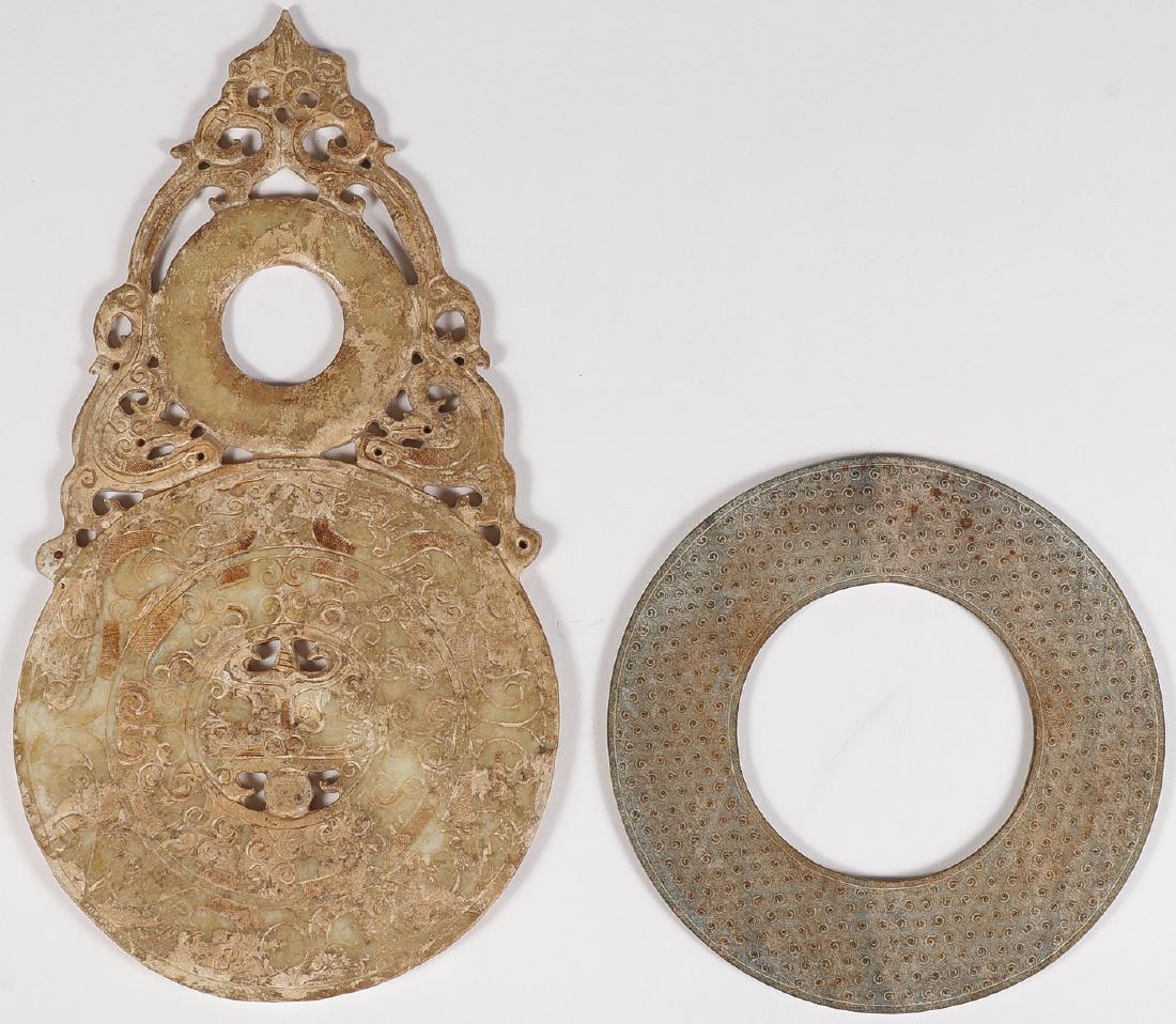TWO CHINESE CARVED ARCHAIC STYLE HARDSTONE DISCS: TWO CHINESE CARVED ARCHAIC STYLE HARDSTONE DISCS. Comprising a double carved disc with open work, carved on both sides with scrolling foliage and dragon motifs. The other with surface overall carved w