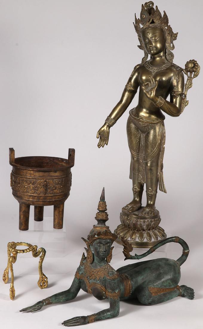 A GROUP OF ASIAN METALWARE: A GROUP OF ASIAN METALWARE. Comprising a large cast bronze standing Buddha, a Taiwanese recumbent animal-human form, a cast iron Archaic style censer, and a gilt-metal stand with dragon form legs. Gre
