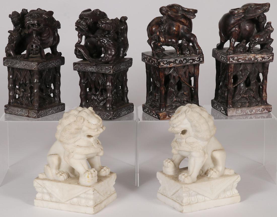 SIX CHINESE CARVED HARDSTONE SCULPTURES: SIX CHINESE CARVED HARDSTONE SCULPTURES. Comprising four large carved stone seals, two mounted with water buffalo and two mounted with Foo dogs above jungle scenes with bamboo style columns on each co