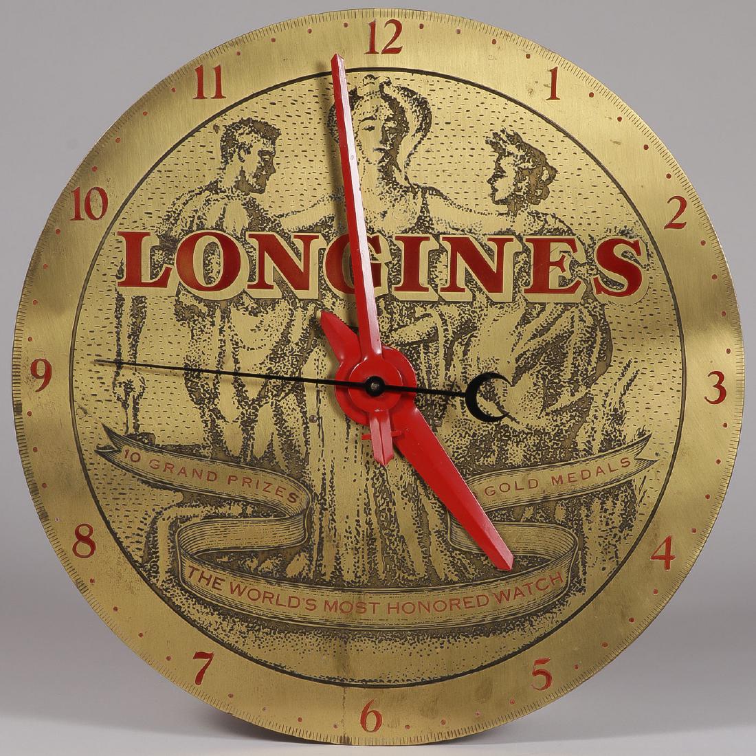 A SCARCE LONGINES ADVERTISING WALL CLOCK: A SCARCE LONGINES ADVERTISING WALL CLOCK. The large brass dial etched and with red enameled numbers and hands. Diameter 18.5 inches.