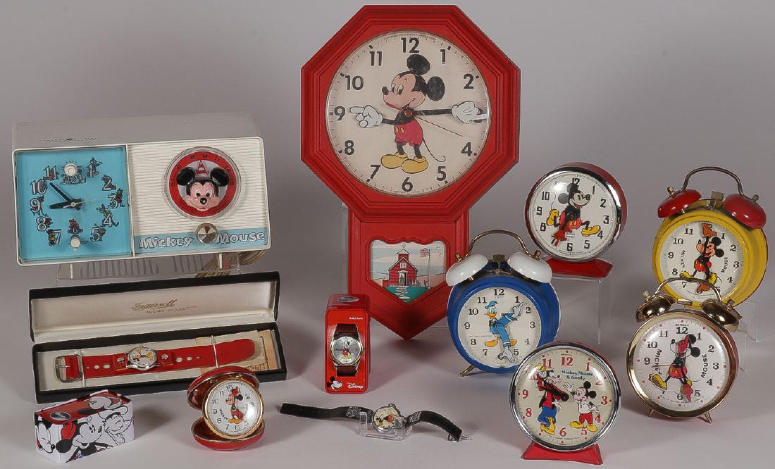 A GROUP OF 11 DISNEY CLOCKS AND WATCHES: AN INTERESTING GROUP OF 11 DISNEY CLOCKS AND WATCHES. Comprising of pair of Mickey Mouse Ingersoll watches, one with a red leather strap contained in original box and the other on a black leather stra