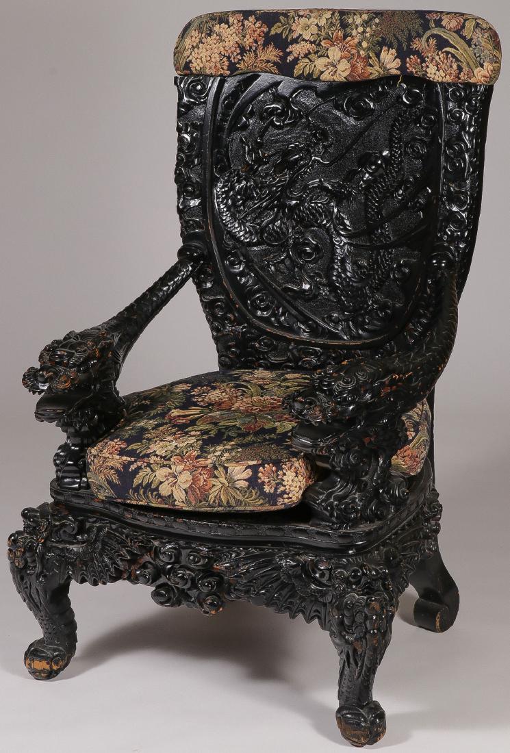 LARGE CHINESE CARVED THRONE CHAIR: LARGE CHINESE CARVED THRONE CHAIR. The large and impressive carved and ebonized wood chair with ornate high-relief carved backrest of a dragon and the arms carved to represent dragon heads with heavil