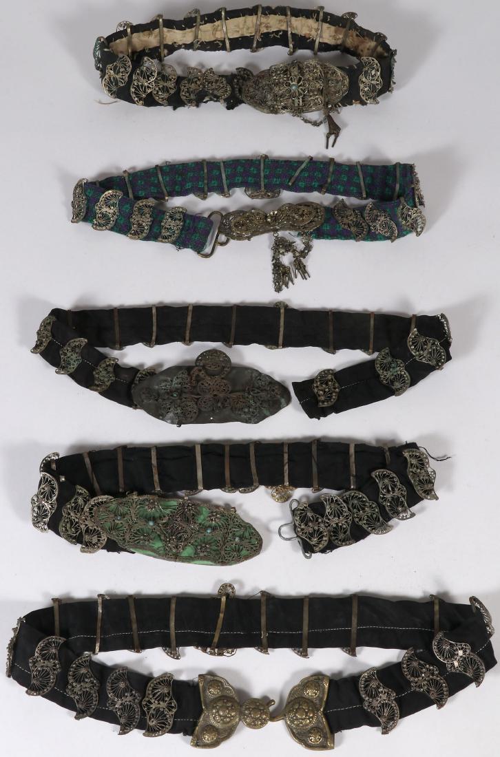 FIVE ETHNIC FILIGREE BELTS, 19TH CENTURY: FIVE ETHNIC FILIGREE BELTS, 19TH CENTURY. Each with ornate filigree buckles and links, some set with faux gemstones and mounted on various types of cloth. Greatest length 36 inches (91.5 cm).