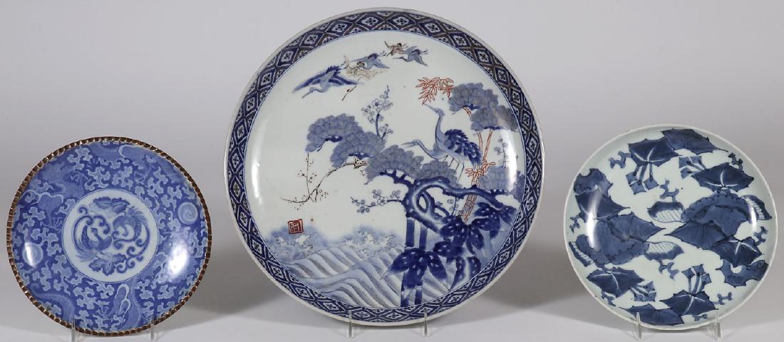 JAPANESE IMARI PORCELAIN, EDO - MEIJI: JAPANESE IMARI PORCELAIN CHARGER AND PLATES, EDO - MEIJI PERIOD. Comprising a large charger decorated with cranes in a mountainous landscape, diameter 15.75 inches (40 cm). Together with two Japanese 