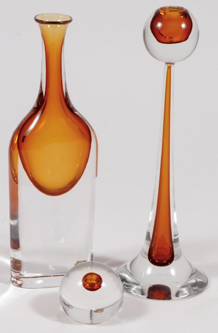 GINO CENEDESE MURANO GLASS: A GROUP OF THREE MURANO GLASS PIECES, GINO CENEDESE. Comprising a bottle form bud vase signed on bottom, a candle stick holder signed on bottom, and a paperweight (unsigned). Greatest height 14.5 inc