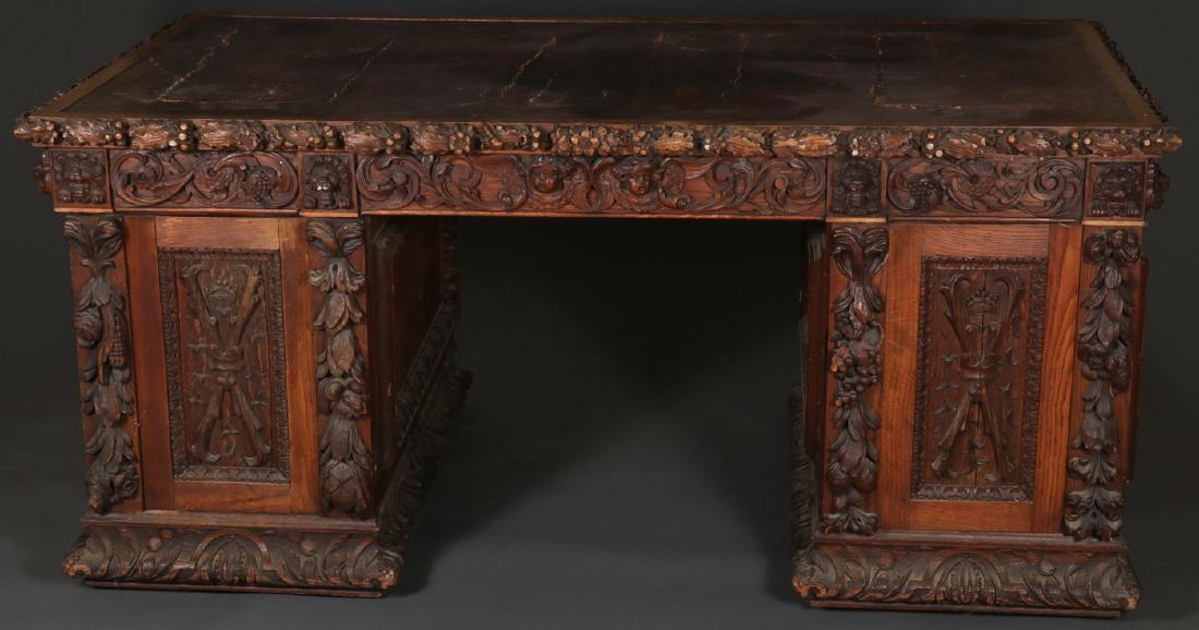 AN ORNATE CARVED OAK PARTNERS DESK, 19TH CENTURY: AN ORNATE CARVED OAK PARTNERS DESK, 19TH CENTURY. The bases heavily carved with sunken panels and the doors with crowned monogram and border carved with a harvest of various produce including corn, gr