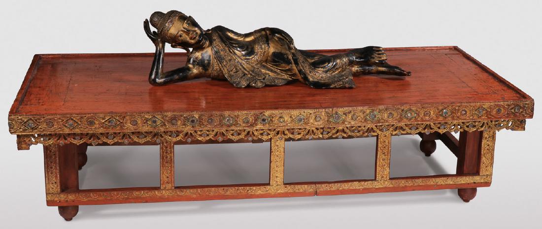 A CARVED AND GILT WOOD RECLINING BUDDHA: A CARVED AND GILT WOOD RECLINING BUDDHA ON PLATFORM. Comprising a separately carved gilt wood Buddha in a reclining position carved in full round of good detail and proportions and resting on a reddis