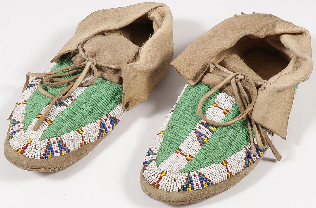 A PAIR OF PLAINS BEADED MOCCASINS, CIRCA 1910: A PAIR OF PLAINS BEADED MOCCASINS, CIRCA 1910. Sinew-sewn hard soles in good condition. Length 9 inches. SHIPPING NOTICE: Jackson's is your sole and only source for one stop packing