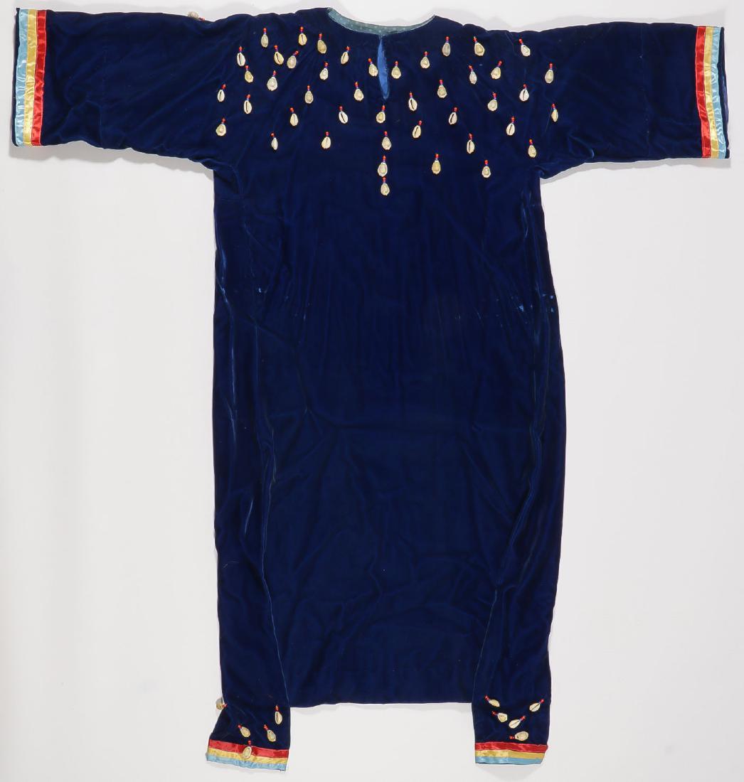 A PLAINS VELVET BEADED DRESS: A PLAINS BEADED DRESS. The hand sewn velvet body with silk multi-colored cuffs and hem drops, and with cowrie shell drops on front and back, probably after 1950. Length 49.5 inches. SHIPPING NOTIC